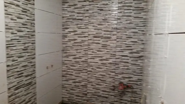 Baño alicatado con revestimiento gris
